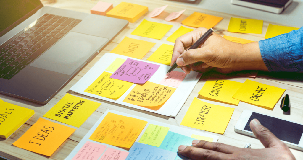 A man writing on sticky notes with thoughts about marketing